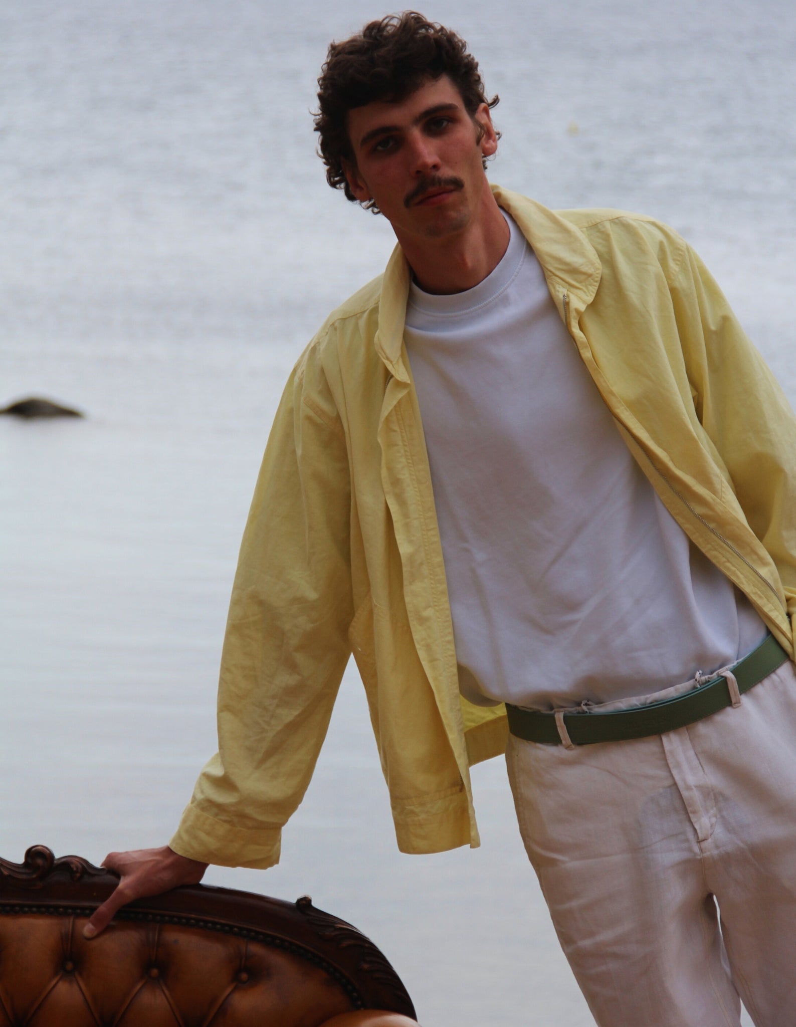 Se ve a un chico joven con un cinturón de cuero balteus en la playa