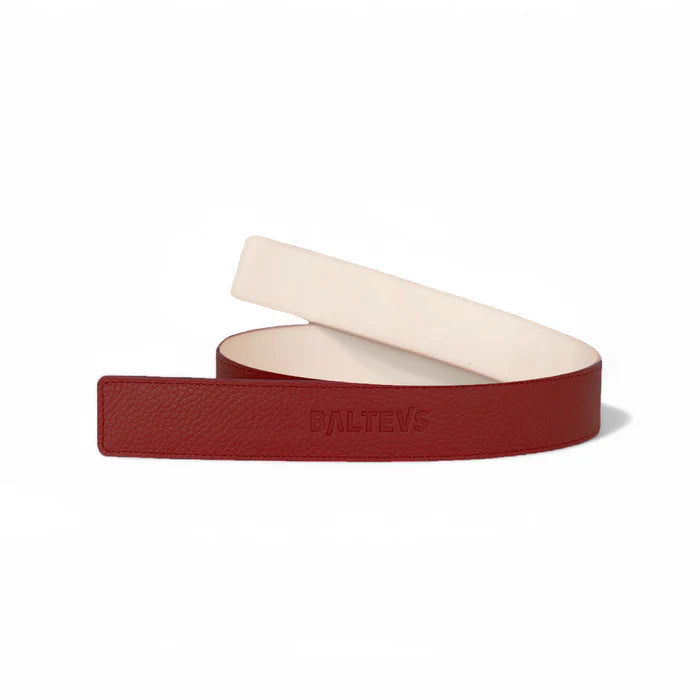 En la foto aparece un cinturon enrollado, con cuero de color rojo cereza en la parte frontal y el sello de Balteus. En la parte trasera se usa cuero de color blanco. Se trata de un cinturón de velcro Balteus.