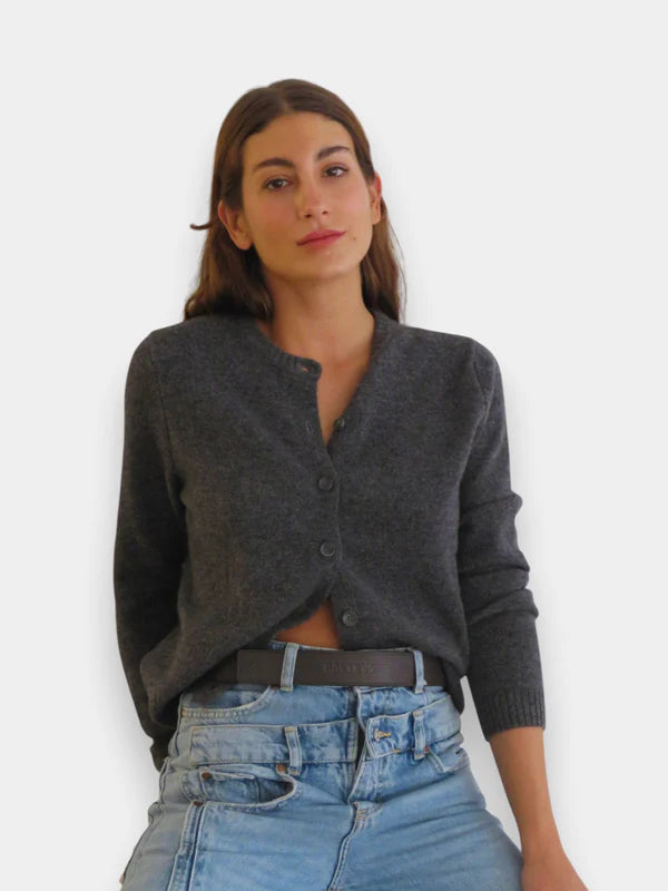 En la foto aparece una chica que lleva un cinturon balteus de cuero marron chocolate y con cierre de velcro, sujetando unos jeans azules y un jersey gris.