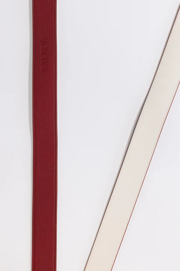 En la foto aparecen dos tiras de cinturón, una de color rojo cereza con el sello balteus y otra blanca. Se hace referencia al cinturón Balteus con cierre de velcro.