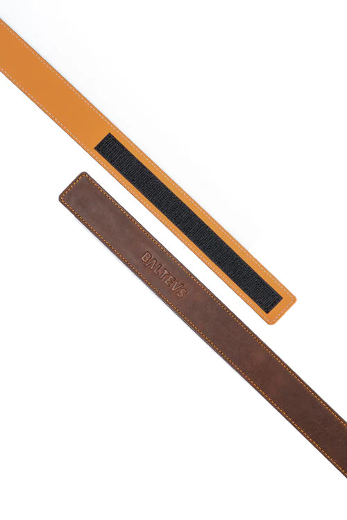 En la foto aparecen dos tiras de cinturón, una de color marron con el sello balteus y otra marrón con velcro. Se hace referencia al cinturón de bufalo Balteus con cierre de velcro.